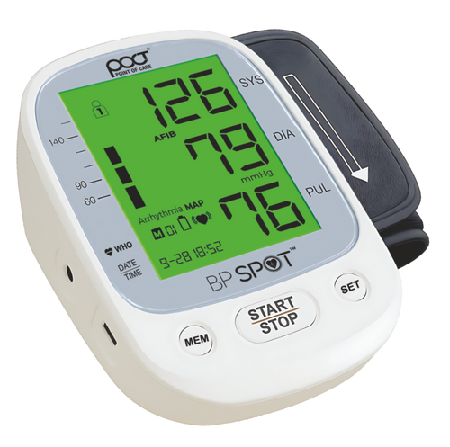 A Poct brand BP Spot digital upper arm blood pressure monitor with a white casing, gray cuff, and a bright green display screen showing readings.